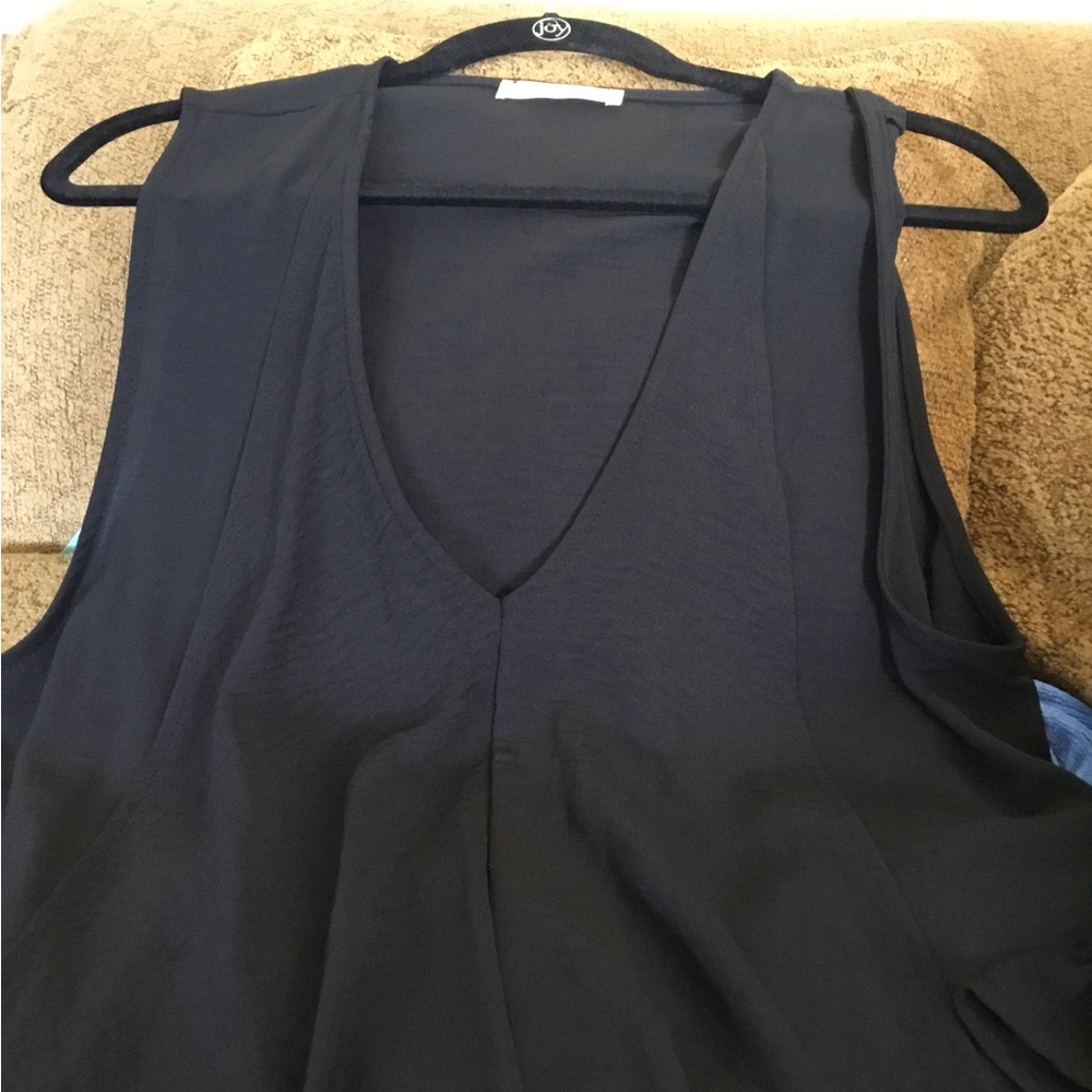 Black sleeveless dress with flowy panels hanging down the front.